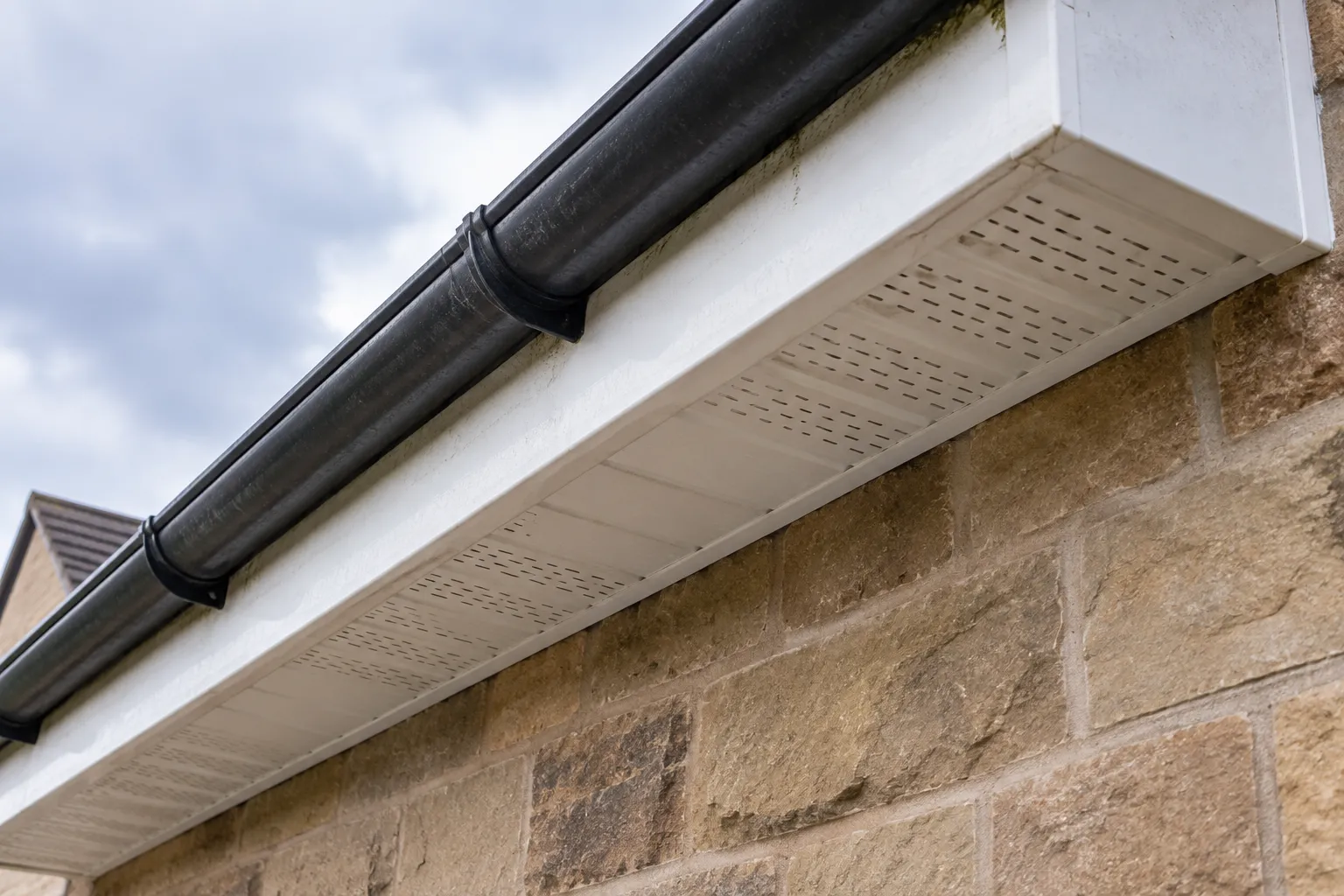 Illustrative roofline showing white fascia, ventilated soffit and dark gutter